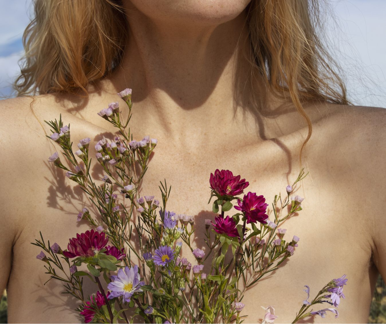 Jeune femme tenant des fleurs dans sa main, photo représentant le confort féminin.